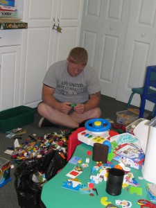 Ryan Lose takes a break from book duty and tries to organize Legos and other small toy pieces.