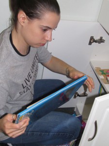 Day of Caring volunteer Frankie Masters stocks a kid’s book in the Forbes House playroom.