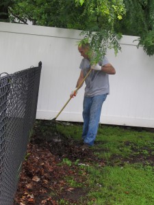 Dave Berrow, an Avery Denison Day of Caring volunteer, rakes leaves around the grounds at Forbes House.