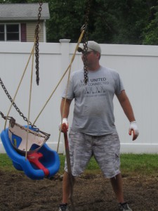 Day of Caring volunteer Scott Noerr of Avery Dennison assesses the weed situation on the  Forbes House playground on June 25th Caring Team working at the shelter following completion of their own project. . Noerr and four others came to help out the Day of